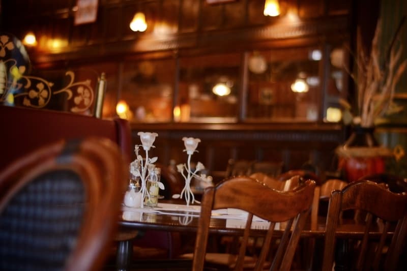 Gastraum der Brasserie Engel mit Holzstühlen, Kronleuchtern und gedeckten Tischen